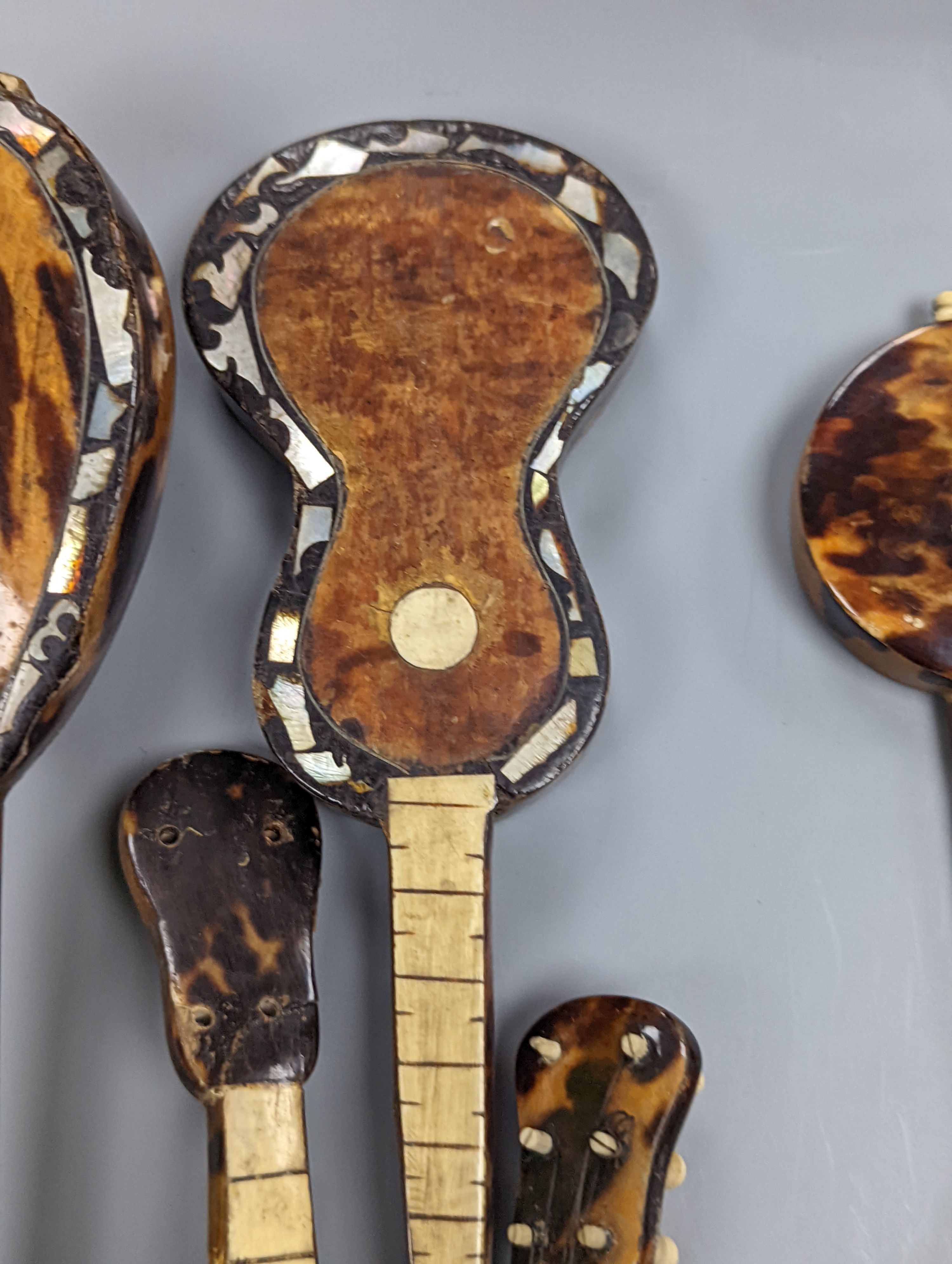 Five 19th century tortoiseshell miniature stringed instruments, longest 20cm.